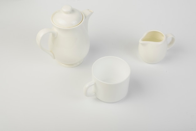 Brocca di latte; tazza e teiera in ceramica su sfondo bianco