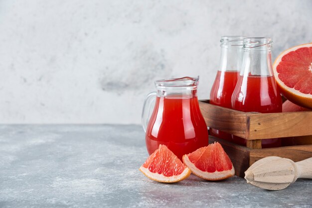 Brocche di vetro di succo di pompelmo con fettine di frutta.