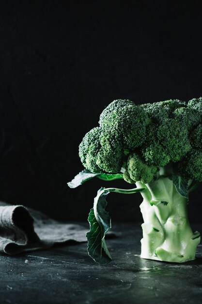 Broccoli del primo piano su fondo e sul panno neri