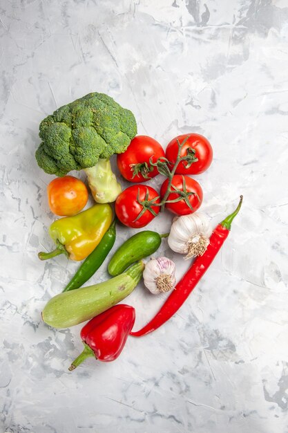 Broccoli freschi di vista superiore con le verdure sulla salute matura dell'insalata della tavola bianca