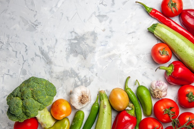 Broccoli verdi freschi di vista superiore con le verdure sulla dieta di salute matura dell'insalata della tavola bianca