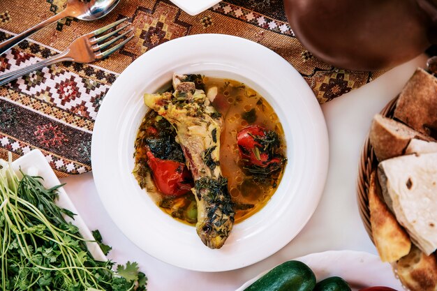 Brodo di carne con pomodoro ed erbe.