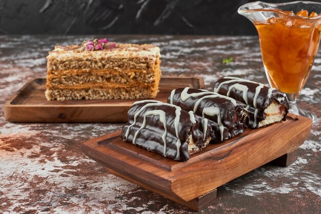 Brownie al cioccolato con una fetta di torta su una tavola di legno.