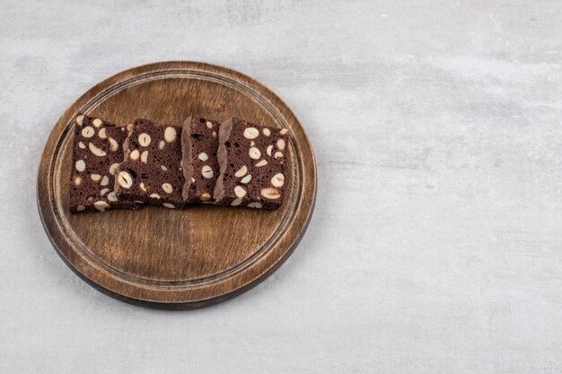 Brownie al cioccolato fatti in casa su un piatto di legno, sul tavolo di marmo.