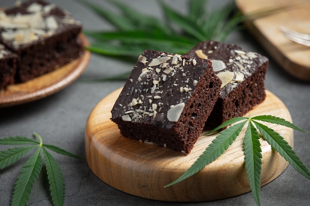 Brownie alla cannabis e foglie di cannabis messe sul tagliere di legno