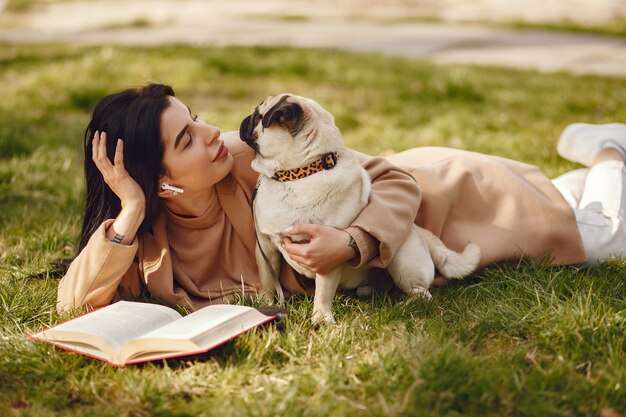 Bruna in un cappotto marrone cammina con pug