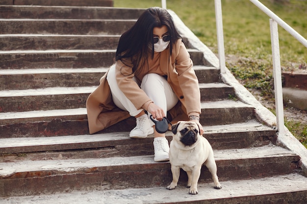 Bruna in una maschera cammina con pug