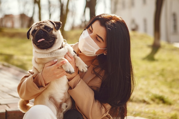 Bruna in una maschera cammina con pug