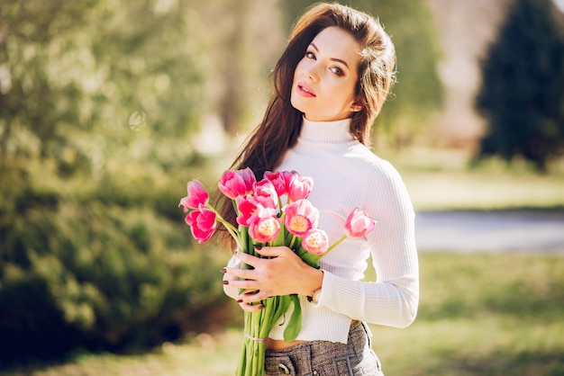 Brunette elegante in un parco di estate