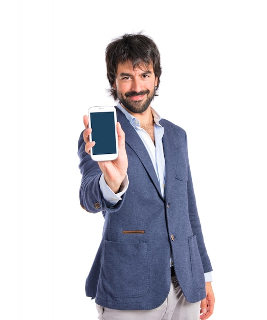 Brunetteman mostrando un cellulare su sfondo bianco