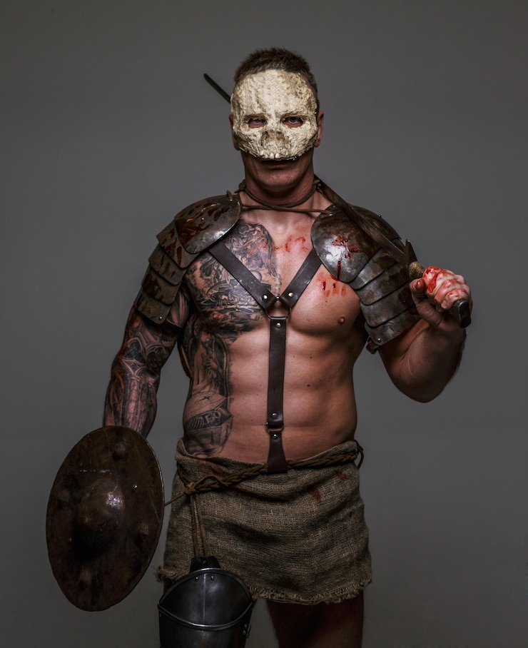 Foto gratuito brutale pericoloso combattente medievale tatuato con maschera di teschio in armatura