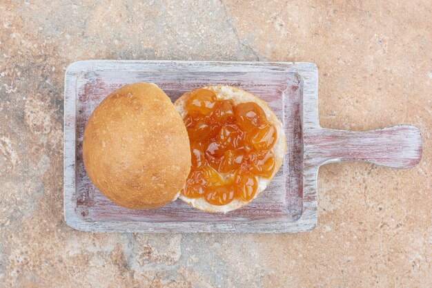 Bun e marmellata di frutti di bosco su tavola di legno