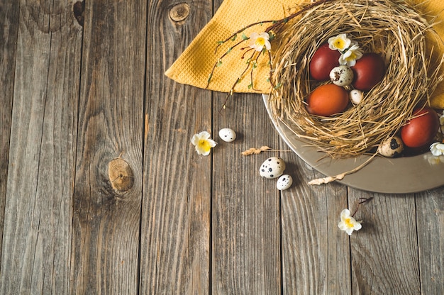 Buona tavola di Pasqua. Uova di Pasqua In un nido su una piastra di metallo su una tavola di legno. Buona Pasqua