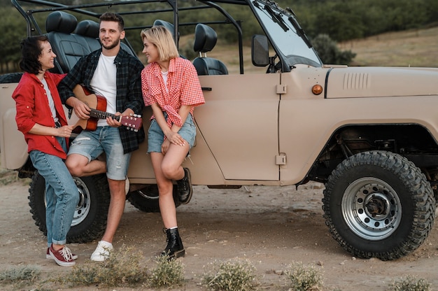 Buoni amici che suonano la chitarra mentre viaggiano in auto