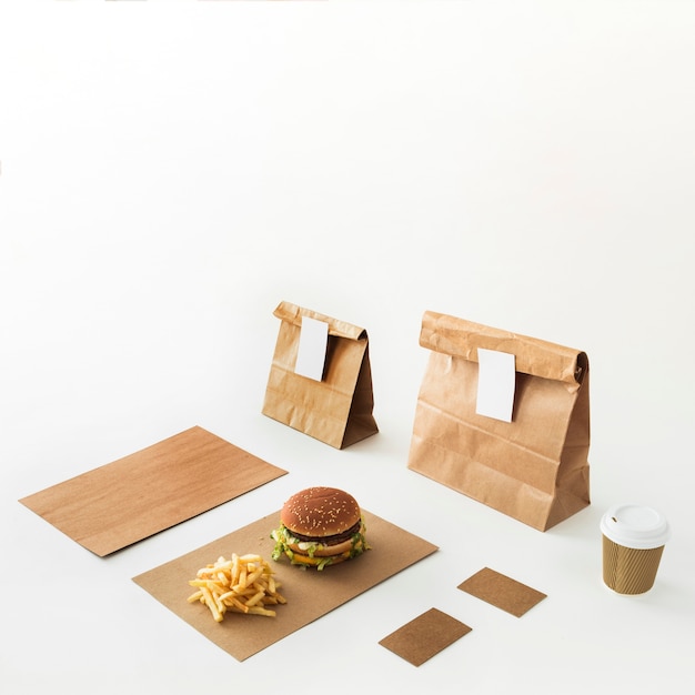 Burger; tazza di smaltimento; patatine fritte e pacco alimentare isolato su sfondo bianco