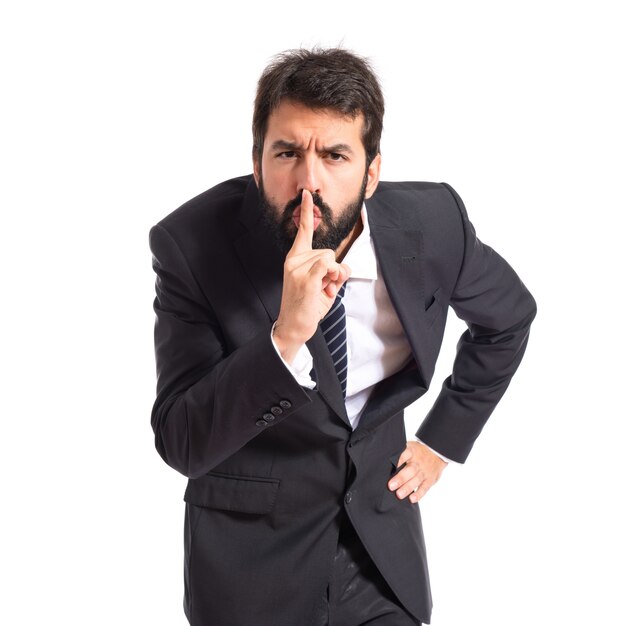 Businessman facendo gesto di silenzio su sfondo bianco isolato