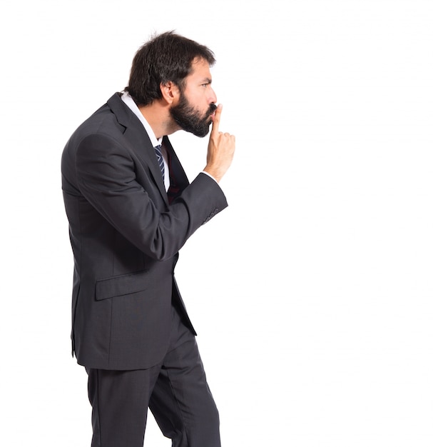 Businessman facendo gesto di silenzio su sfondo bianco isolato