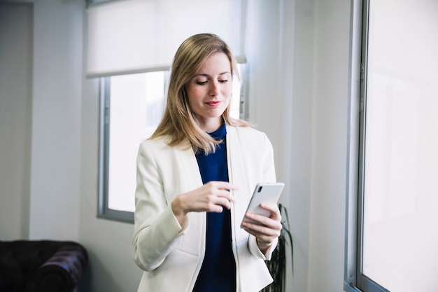 Businesswoman di contenuto guardando smarphone