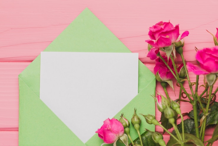 Foto gratuito busta verde con nota vuota e le rose