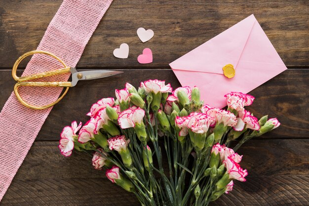 Busta vicino a bouquet di fiori, forbici e nastro