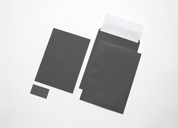 Buste di carta nere vuote, carta intestata e carta isolato su bianco. Illustrazione 3D