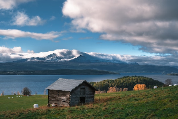 Cabina di legno su un bellissimo campo vicino a un lago calmo durante il giorno