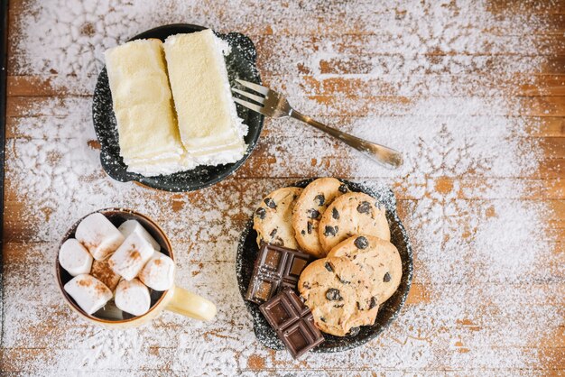 Cacao con dolci su tavolo decorato con zucchero a velo