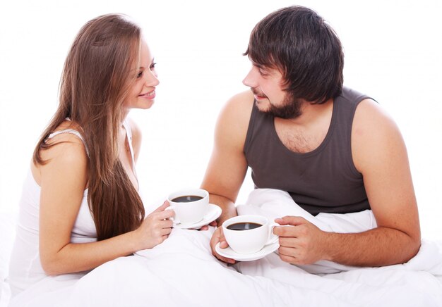 Caffè bevente delle giovani coppie a letto