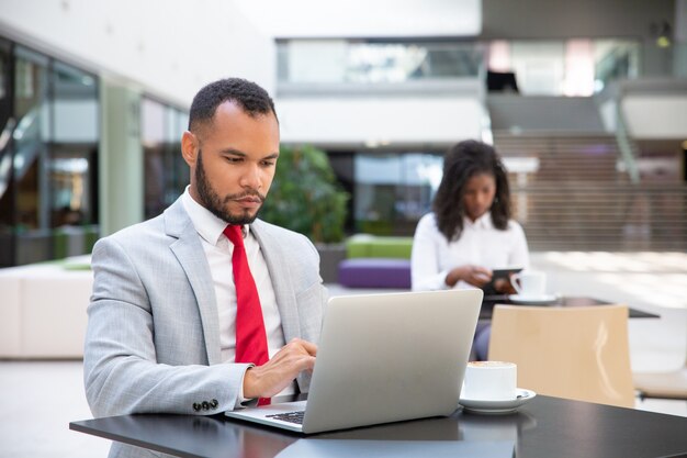 Caffè bevente e lavoro dell'uomo d'affari serio