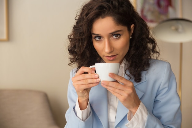 Caffè bevente professionale femminile pensieroso a casa