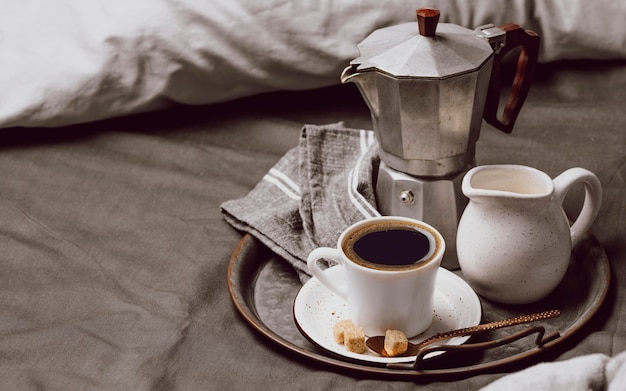 Caffè del mattino sul letto con latte e copia spazio