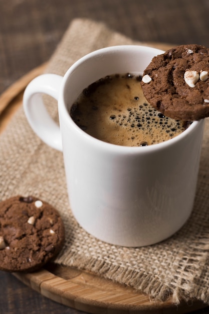 Caffè della prima colazione nell'alta vista bianca dei biscotti e della tazza