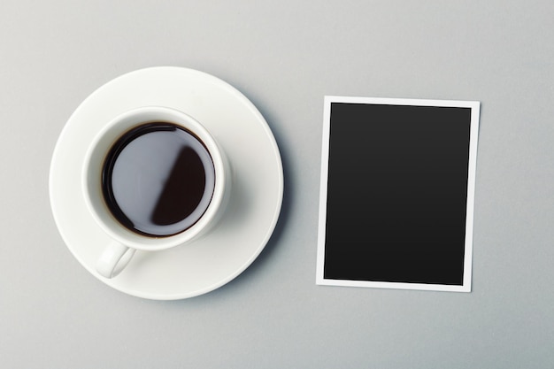 Caffè e foto in bianco sul tavolo