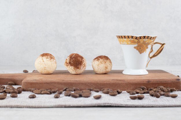 Caffè espresso e biscotti sul bordo di legno con i chicchi di caffè