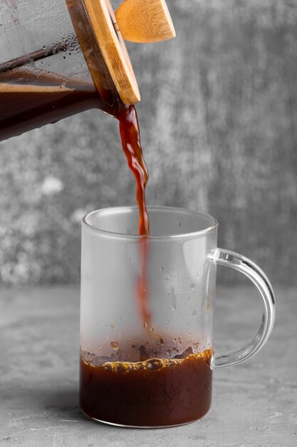 Caffè fresco del primo piano che versa nella tazza