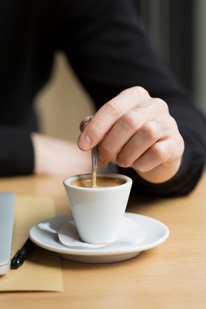 Caffè godente maschio di affari del primo piano