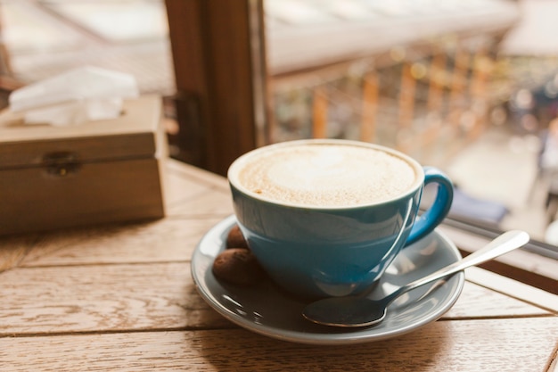 Caffè gustoso con deliziosi biscotti sul tavolo di legno