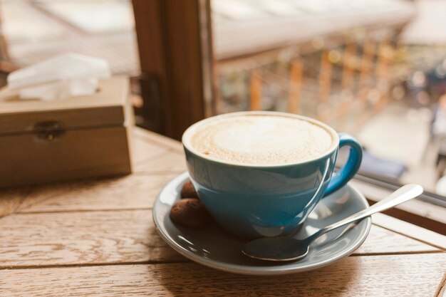 Caffè gustoso con deliziosi biscotti sul tavolo di legno