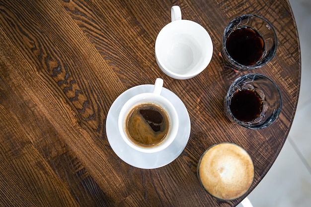 Caffè in una tazza e in bicchieri su un tavolo in legno vista dall'alto