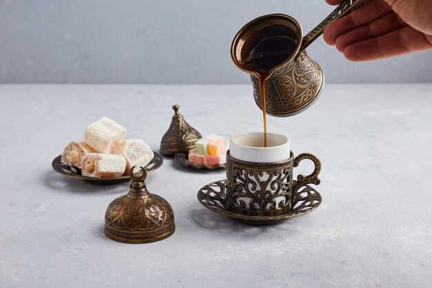 Caffè turco nella pentola e tazza metalliche.