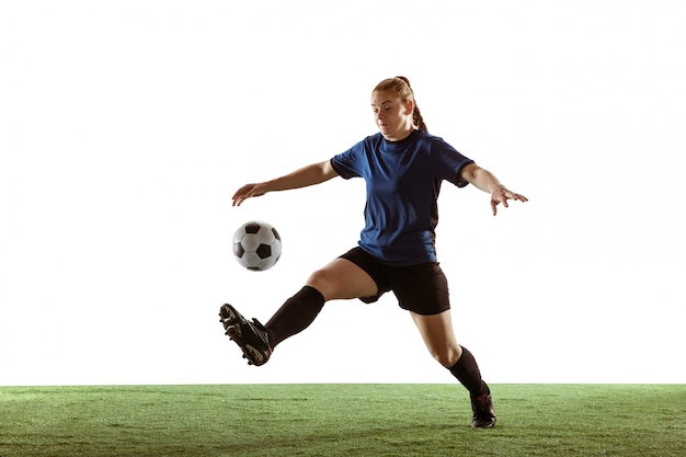 Calcio femminile, giocatore di football americano che dà dei calci alla palla, preparandosi nell'azione e moto isolato su fondo bianco