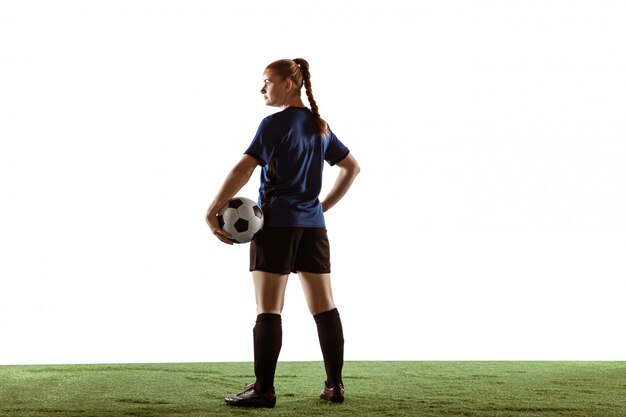 Calcio femminile, giocatore di football americano che dà dei calci alla palla, preparandosi nell'azione e moto isolato su fondo bianco