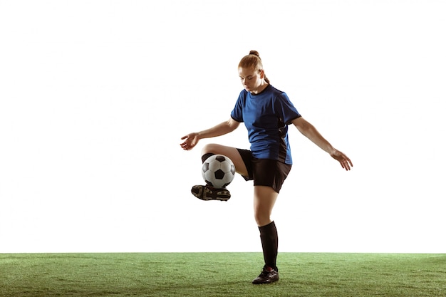 Calcio femminile, giocatore di football americano che dà dei calci alla palla, preparandosi nell'azione e moto isolato su fondo bianco