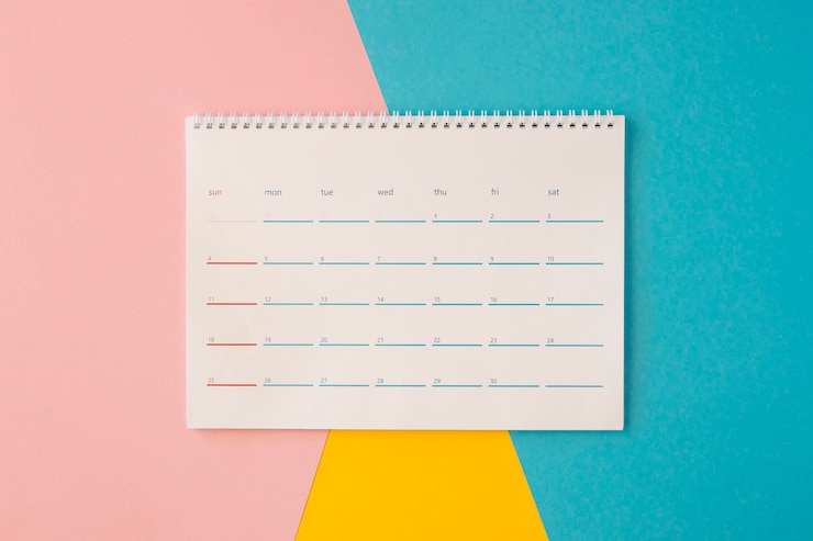 Foto gratuito calendario da tavolo vista dall'alto su sfondo colorato