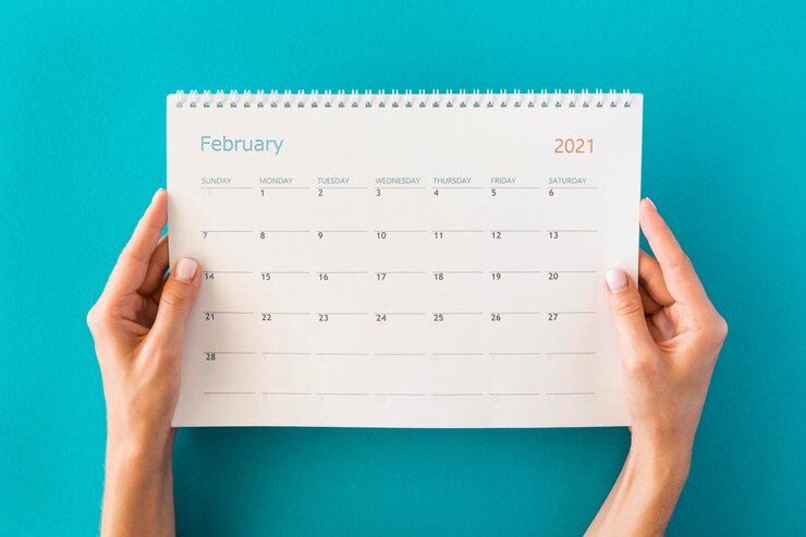 Foto gratuito calendario e mani del pianificatore di vista superiore