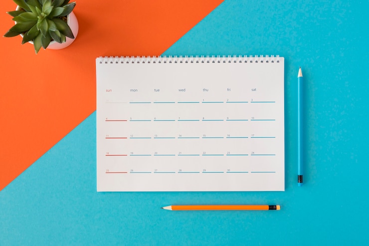 Foto gratuito calendario e matite della cancelleria di vista superiore