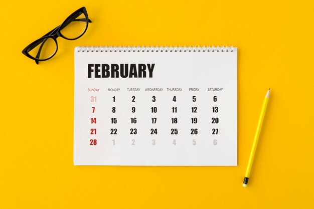 Calendario pianificatore piatto laici su sfondo giallo