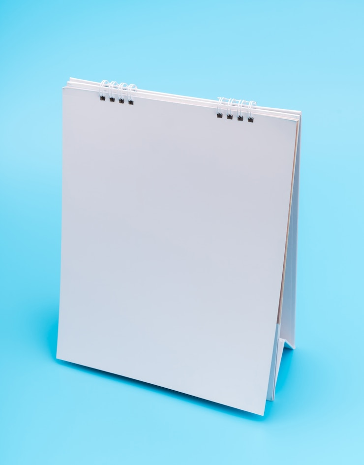 Foto gratuito calendario vuoto tavolo con pagine, isolato su sfondo blu.