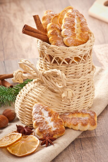 Calza natalizia in vimini riempita con biscotti, bastoncini di cannella, limone candito e anice stellato