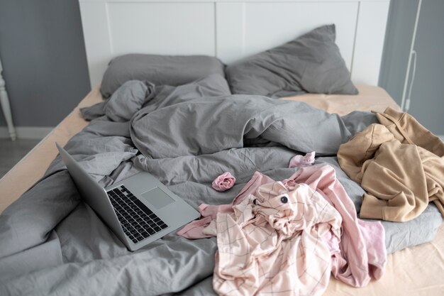 Camera da letto disordinata con vestiti sul letto